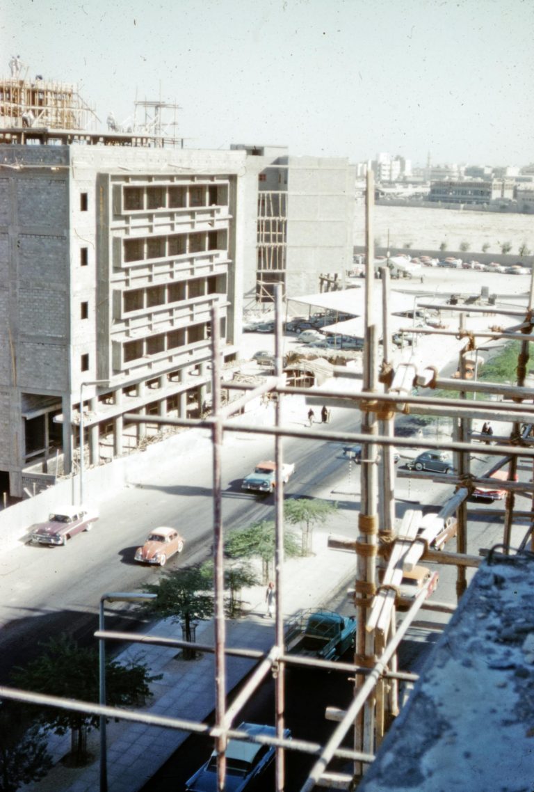 A high-angle view of a vintage construction site with vehicles on the road in Kuwait.